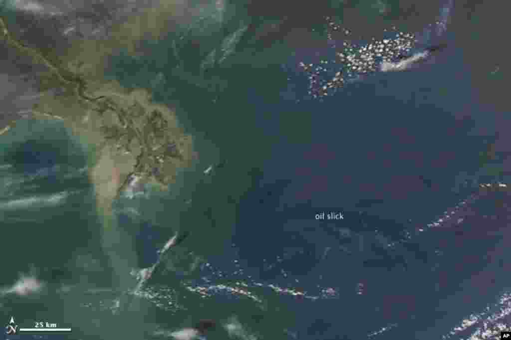 An oil slick in the Gulf of Mexico comes within 20 miles of barrier islands and beaches in Louisiana, 27 Apr 2010. (NASA Image)