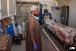 Un trabajador palestino se encuentra en una morgue cerca de un cadáver en un hospital tras un bombardeo israelí, el 7 de septiembre de 2024, en Deir el-Balah, en el centro de la Franja de Gaza. (Foto de Eyad BABA / AFP)