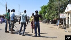 Vigilante barricade the road following an explosion at a market in Maiduguri, Nigeria, Dec. 1, 2014, with twin blasts exploding at a crowded market in Maiduguri and explosions and gunshots erupting in Damaturu. 