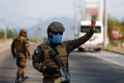 Un soldado detiene un automóvil en un puesto de control durante una cuarentena en todo el país, mientras el gobierno tomó medidas cada vez más estrictas para prevenir una posible propagación del COVID-19, en San Salvador, el 29 de marzo del 2020.