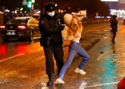Riot police detain a young woman during a protest against the jailing of opposition leader Alexei Navalny in Pushkin square in Moscow, Russia, Jan. 23, 2021. Russian police made thousands of arrests in nationwide protests.