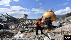 Dua anggota SAR terus melakukan pencarian korban di perumahan Balaroa di Palu, Senin, 8 Oktober 2018. Kawasan itu paling terdampak bencana gempa dan tsunami pada 28 September 2018.