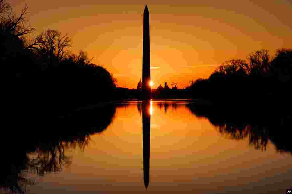 The sun rises behind the Washington Monument on an early spring morning in Washington, D.C.