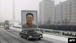 Cenaze kortejinin önünde Kim Jong İl'in dev bir portresi taşındı