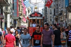 People walk in central Istanbul's Istiklal Avenue, the main shopping road of Istanbul, Aug. 22, 2018.