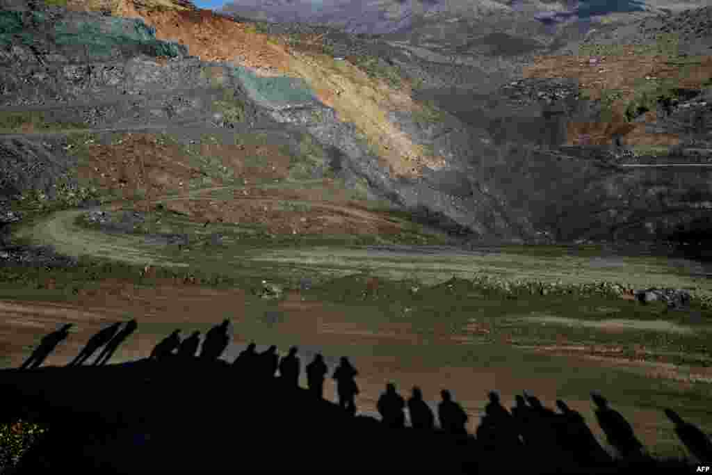 The shadows of relatives of miners are cast on the ground as they wait, while rescue workers search for trapped miners at the accident site in the southeastern Siirt province, Turkey.