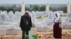 FILE - A woman reacts at a grave of her daughter, an SDF fighter killed during fightings with Islamic State militants, at a cemetery in Kobani, Syria April 4, 2019.