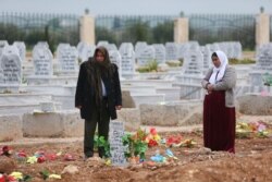 FILE - A woman reacts at a grave of her daughter, an SDF fighter killed during fighting with Islamic State militants, at a cemetery in Kobani, Syria, April 4, 2019.