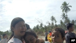 Tsunami survivors weep on ravaged Pagai island, in Mentawai Islands, Indonesia, 28 Oct. 2010.