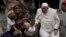 ARCHIVO - El Papa Francisco toma la mano de un niño pequeño mientras saluda a los fieles al final de su audiencia general semanal en el Aula Pablo VI, en el Vaticano, el 12 de febrero de 2025.