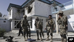 Afghan policemen display confiscated arms belonging to insurgents after a suicide bomb attack followed by a gun battle between the insurgents and U.S. and Afghan forces at a building used by the Office of the United Nations High Commissioner for Refugees 