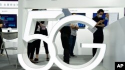 Visitors walk past a 5G sign at the China Beijing International High Tech Expo in Beijing, China. (File)
