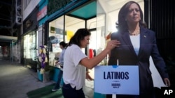 Emiliana Guereca, presidenta y fundadora de la Women's March Foundation, ajusta una imagen de la vicepresidenta Kamala Harris en Los Ángeles el 15 de octubre de 2024. (AP foto/Damian Dovarganes).