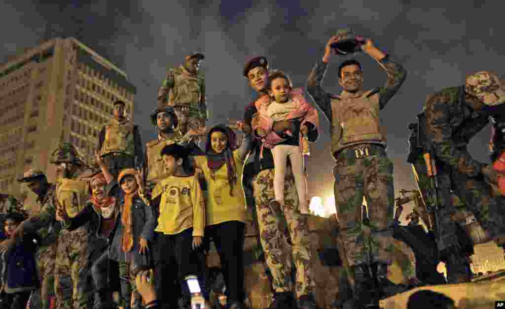 Egyptian Army soldiers celebrate with children on their armored personnel carrier, as they celebrate the news of the resignation of President Hosni Mubarak, Feb. 11, 2011