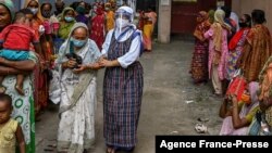 FILE - Nuns from Missionaries of Charity distribute food to the needy on the occasion of 'Peace Day' to mark the death anniversary of Mother Teresa at the Mother House in Kolkata on Sept. 5, 2021. 