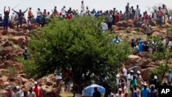 FILE - Miners gather on a hill during their strike at the AngloGold Ashanti Mine in Fochville near Johannesburg, South Africa, Oct. 19, 2012.