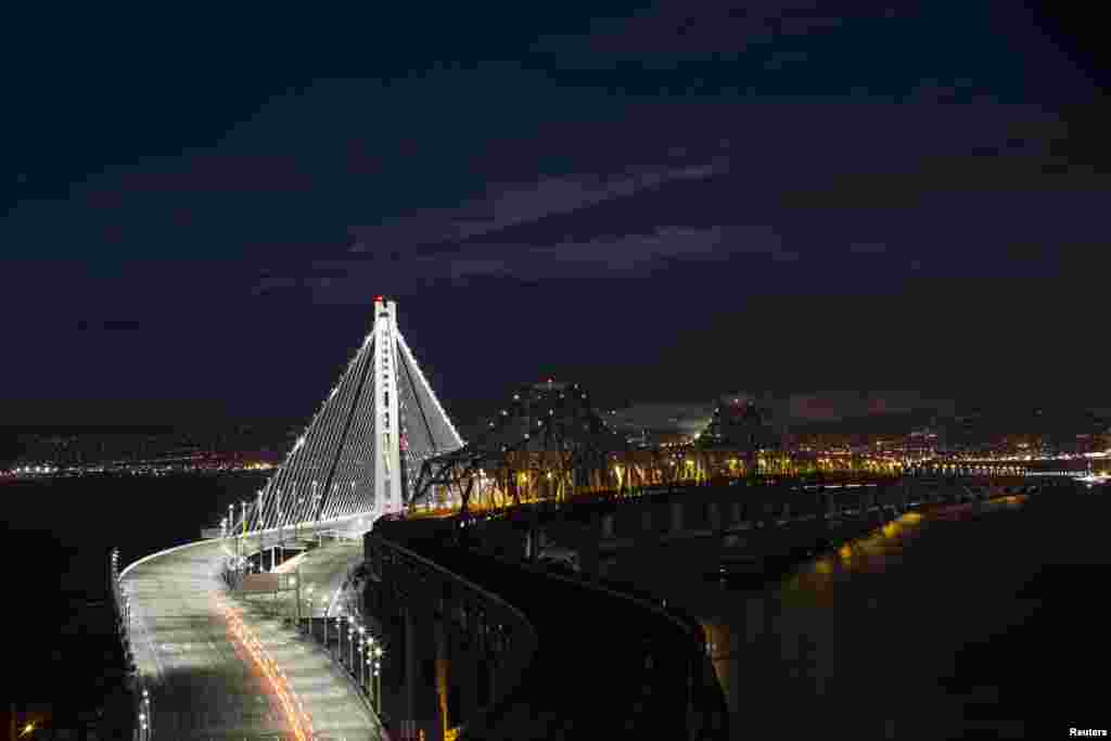 Lampu-lampu pada jembatan &#39;Bay&#39; - yang menghubungkan kota San Francisco-Oakland - tampak menyala di kota San Francisco, negara bagian California, AS.