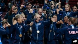 The U.S. team celebrates after winning the women's Volleyball World Championships final match against China in Milan, Italy, Oct. 12, 2014.