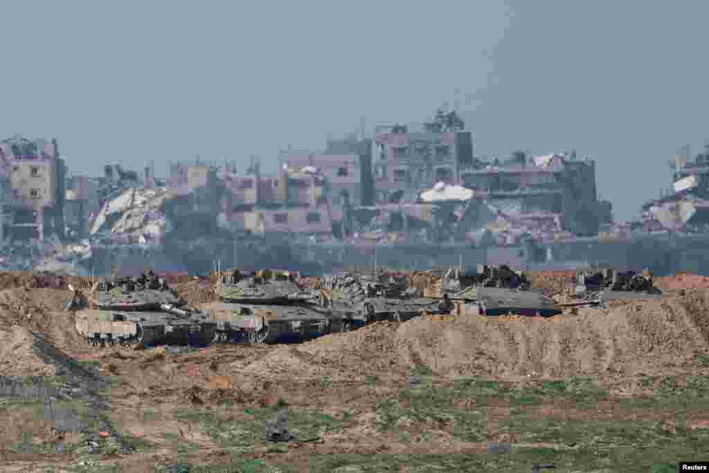 Israeli military vehicles gather inside the Gaza Strip, amid a ceasefire between Israel and Hamas, near the Israel-Gaza border, as seen from Israel, Jan. 19, 2025. 