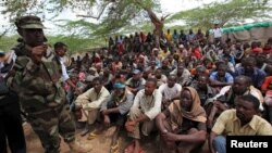 FILE - Members of the militant group al Shabab listen to a Somalia government soldier after their surrender to the authorities in Mogadishu, Sept. 24, 2012.