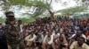 FILE - Members of the militant group al Shabab listen to a Somalia government soldier after their surrender to the authorities in Mogadishu, Sept. 24, 2012.