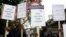 Protesters stand outside Arundel House where President of the Republic of Rwanda, Paul Kagame, deliverers the annual Oppenheimer Lecture, London, Sept. 16, 2010.