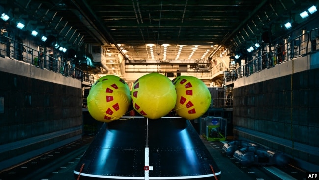 La cápsula de prueba del módulo de tripulación Orion descansa en la cubierta del pozo a bordo del USS San Diego, en la Base Naval de San Diego luego de la Prueba de Recuperación en Marcha 11, en California, el 28 de febrero de 2024.