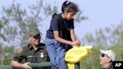 Agentes de la patrulla fronteriza ayudan a una muchacha en el Sur de Texas. El congreso realizará una audiencia este martes para analizar los desafíos en la frontera.