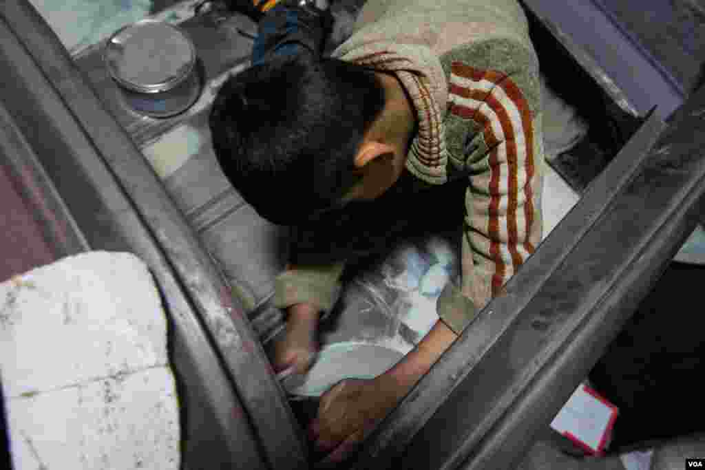 Medyan polishes the boot of a car. The government is currently working on a survey to fully document how prevalent child labour is in Lebanon, John Owens/VOA.