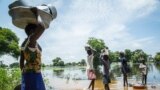 Family tries to cross flooded area after Nile river overflows in central South Sudan.