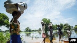 Family tries to cross flooded area after Nile river overflows in central South Sudan.
