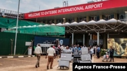 FILE - Passengers arriving on international flights leave the international arrivals lobby at Entebbe Airport in Uganda, March 3, 2020. 