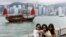 Tourists take photos in front of Victoria Harbor in Hong Kong on April 29, 2024. China's Individual Visit Scheme allows residents from some areas to travel to Hong Kong on their own, rather than in a tour group.