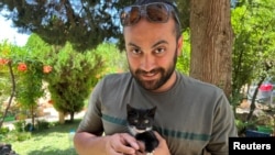 FILE - Reuters visuals journalist Issam Abdallah holds a kitten while posing for a picture in Saaideh, Lebanon, July 4, 2023.