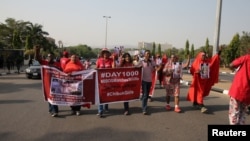 Para peserta kampanye #BringBackOurGirls melakukan rapat akbar di ibukota Nigeria, Abuja tanggal 8 Januari 2017, untuk memperingati 1000 hari sejak 200 murid sekolah perempuan diculik dari sekolah menengah mereka di Chibok oleh sekte Islamis Boko Haram, Nigeria