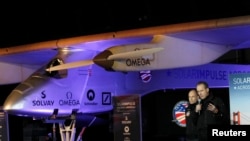 Các phi công Bertrand Piccard (trái) và Andre Borschberg đứng bên cạnh chiếc máy bay Solar Impulse.