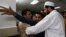 People comfort a man at a local hospital, who lost two cousins in an attack in Peshawar, Pakistan, April 29, 2013.