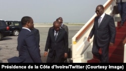 Le président ivoirien Alassane Ouattara descend de l’avion à son retour d’Accra, accueilli au bas de l’échelle par Guillaume Soro, président de l’Assemblée nationale, à Abidjan, Côte d’Ivoire, 7 janvier 2017. (Présidence de la Côte d’Ivoire/Twitter)