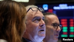 FILE PHOTO: Traders work on the floor of the NYSE in New York
