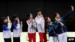 Os medalhistas de ouro Yuting Huang e Lihao Sheng da equipa da República Popular da China os medalhistas de prata Hajun Park e Jihyeon Keum da equipa da República da Coreia e os medalhistas de bronze Alexandra Le e Islam Satpayev da equipa do Cazaquistão tiram uma selfie