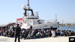 Para migran Afrika dan Timur Tengah menunggu di pantai Sicilia, Italia (foto: dok).