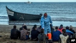 Para migran dari Maroko menjalani pemeriksaan suhu untuk pencegahan virus corona setibanya di Pulau Canary setelah berlayar menyeberangi Samudera Atlantik dengan kapal kayu, 20 Oktober 2020. 