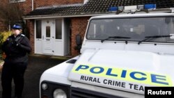 FILE - A police officer stands guard outside of the home of former Russian military intelligence officer Sergei Skripal, in Salisbury, Britain, March 6, 2018. 