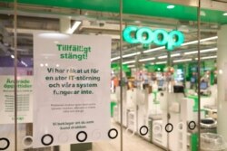 FILE - A sign reads: "Temporarily Closed. We have an IT-disturbance and our systems are not functioning", posted in the window of a closed Coop supermarket store in Stockholm, Sweden, July 3, 2021.