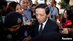 China's special envoy Zhang Yesui (C) leaves after a meeting with Malaysian government officials and authorities working on the missing Malaysia Airlines Flight MH370 at Putra World Trade Center in Kuala Lumpur, March 26, 2014.