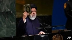 Presiden Iran Ebrahim Raisi mengangkat Al-Qur'an saat berpidato pada sesi ke-78 Majelis Umum PBB di markas besar PBB, Selasa, 19 September 2023. 