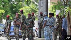 Ivorian soldiers stand guard at the entrance to electoral commission headquarters in Abidjan, 01 Dec 2010