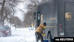 Mike Charnesky, que trabaja de forma remota, ayuda a un camión de reparto de UPS que está atascado en Detroit, Michigan, Estados Unidos, 16 de febrero de 2021.