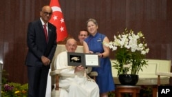 Paus Fransiskus menerima varietas anggrek khusus yang dinamai 'Dendrobium His Holiness Pope Francis' untuk menghormati kunjungannya ke Singapura, 12 September 2024. (Foto: AP)