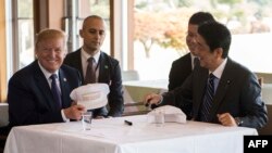 Presiden Donald Trump berbincang dengan Perdana Menteri Jepang, Shinzo Abe, dalam jamuan makan siang di Kasumigaseki Country Club Gold Course di Tokyo, 5 November 2017. 